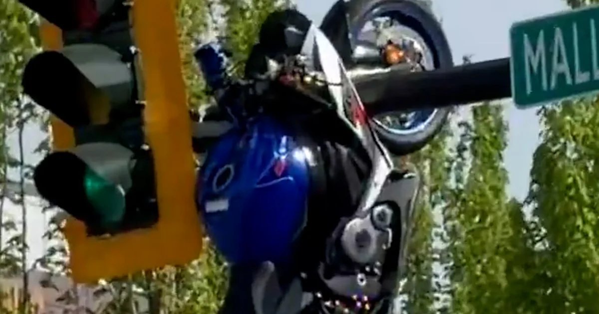 Motorcycle dangles from traffic light after collision