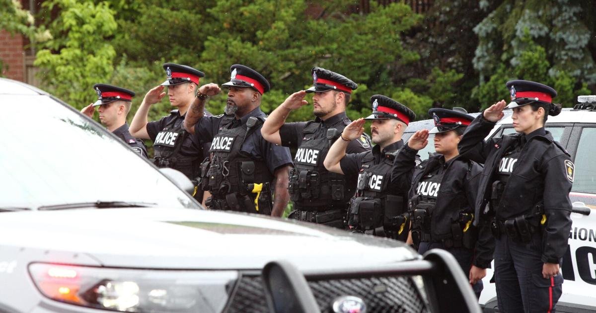 Police officers honour fallen colleague Marc Pinizzotto along funeral procession