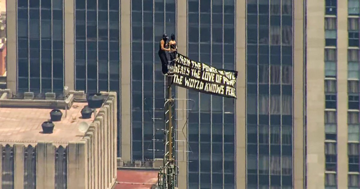 Two trespassers scale Empire State Building to fly peace banner and kiss